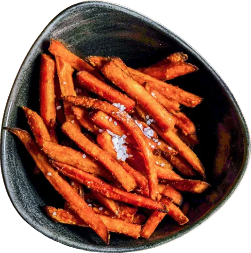Süßkartoffelpommes in einer dunklen Steingutschale, von oben