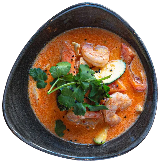 Kokossuppe mit Garnelen und Koriander in einer dunklen Schale, von oben