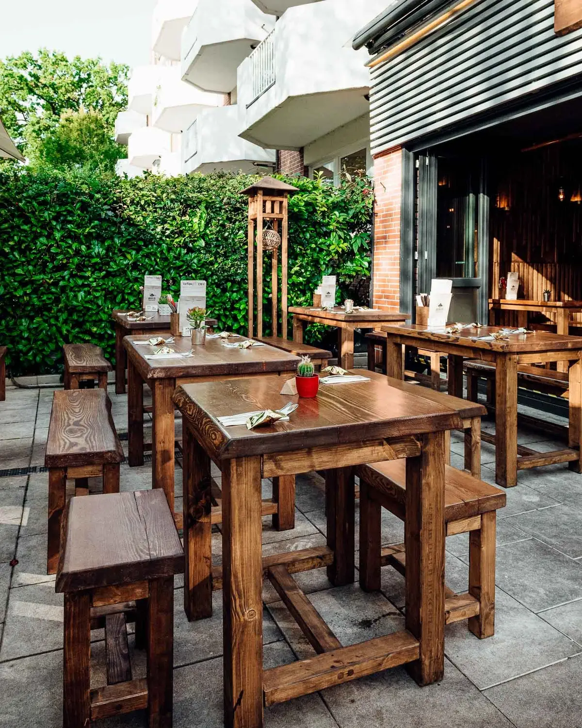 Terrasse des Quán 19 am Hofweg mit Holzbänken und Laternen